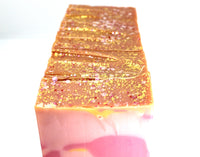 Stacked Swirled pink and yellow soap on white background.