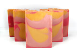 Staggered Swirled pink and yellow soap on white background.