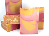 Bars of Swirled pink and yellow soap on white background.
