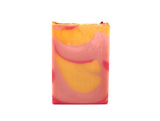 Swirled pink and yellow soap on white background.