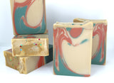 Stacked bars of tan colored soap with copper and green swirls on white background.