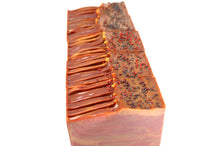 Brown and red swirled bars of soap in front of each other on a white background.